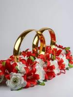Золотые кольца на свадебное авто жениха и невесты с колокольчиками и искусственными лилиями в красной и белой гамме