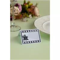 Банкетная карточка для рассадки гостей за столом "Кино" из плотного картона с изображением камеры и кинопленки в черных и белых тонах